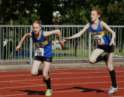 Alice Cribb and Ellie Roberts ensure a safe baton change in the 4 x 100m